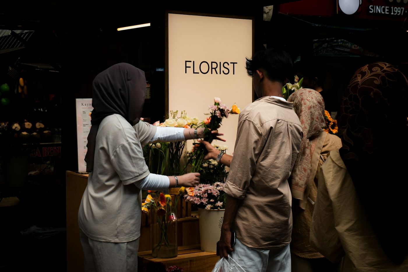 A florist helping customers in a flower shop
