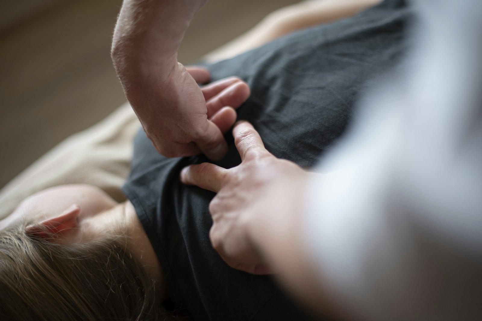 A therapist's hands working on a client's back