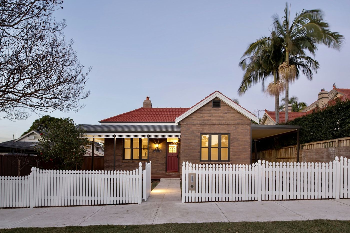 A weatherboard house with a white picket fence