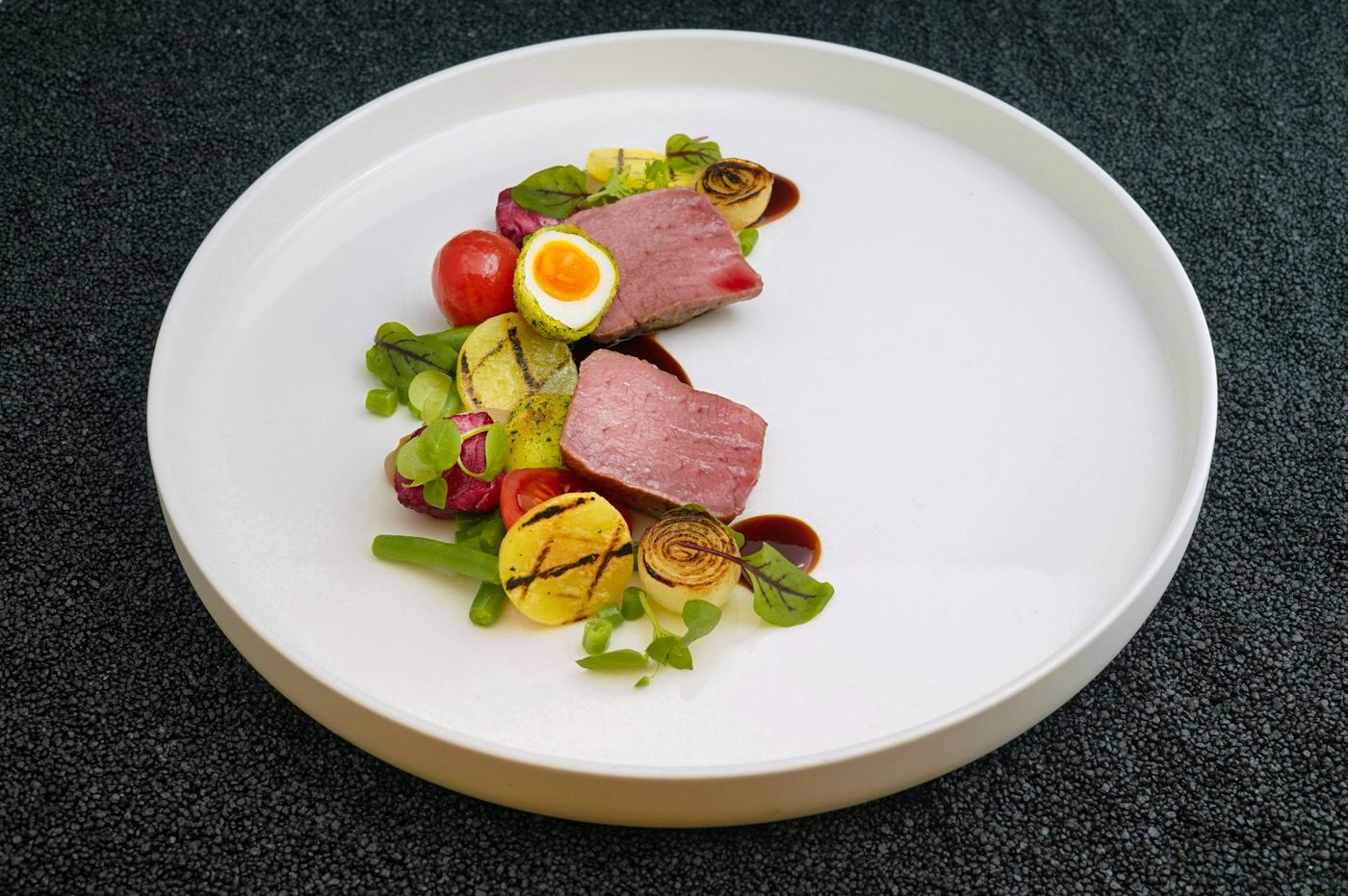 Coal-roasted carrots and beetroot on a white plate